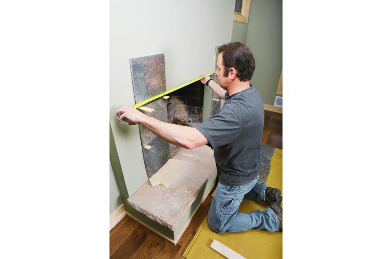 A technician installing a gas fireplace insert.