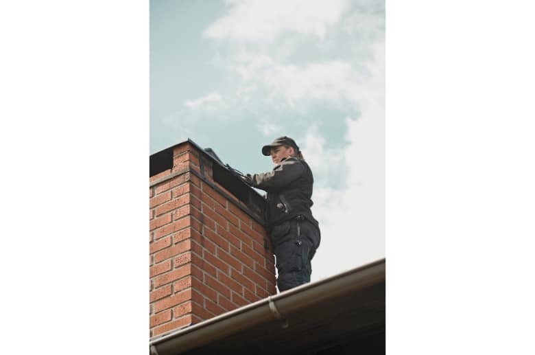 A technician look at the chimney before cleaning.