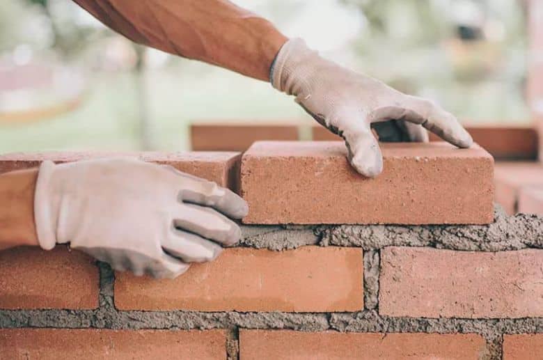 A man rebuilding a brick chimney.
