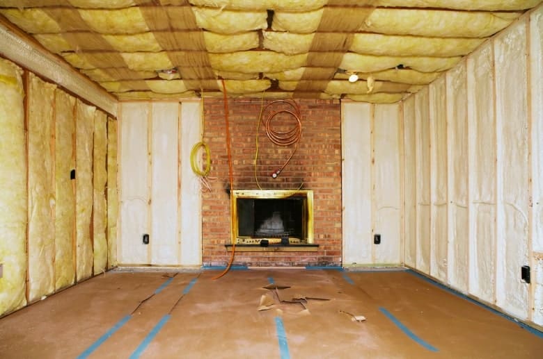 A basement with insulation, large floor area and an electric fireplace.