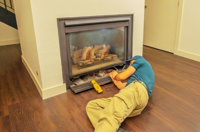 A technician checking the gas fireplace.