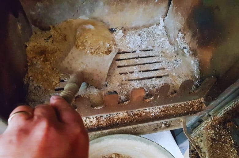 A wood stove being cleaned.