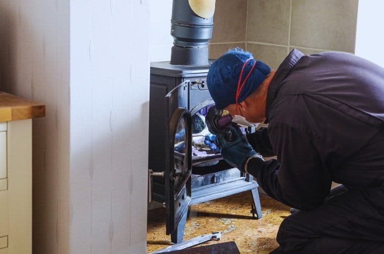 A technician checking a wood stove.