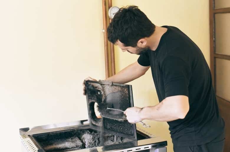 A man cleaning an old wood stove.
