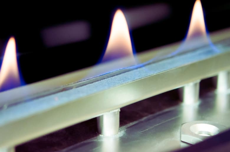 A gas burner. It is one of the considerations when comparing Vented vs Ventless Gas Fireplaces.