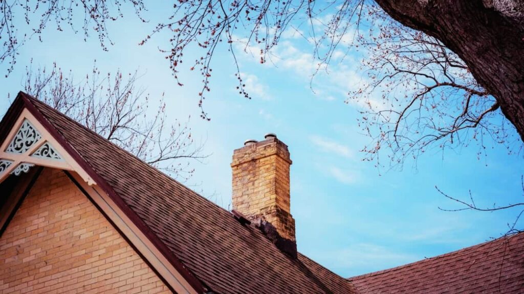 A spalling chimney on a roof of a home.