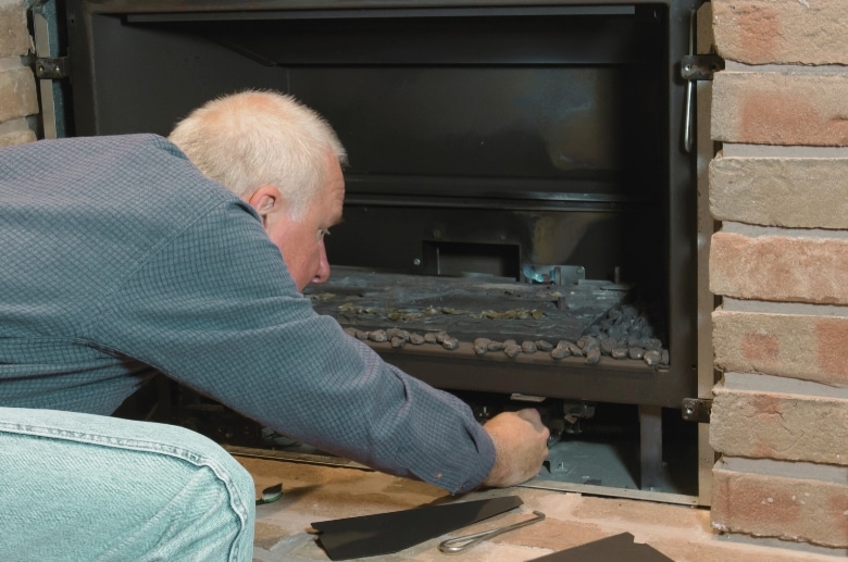 A man maintaining a gas fireplace. This will affect on How Long Can You Run a Gas Fireplace.
