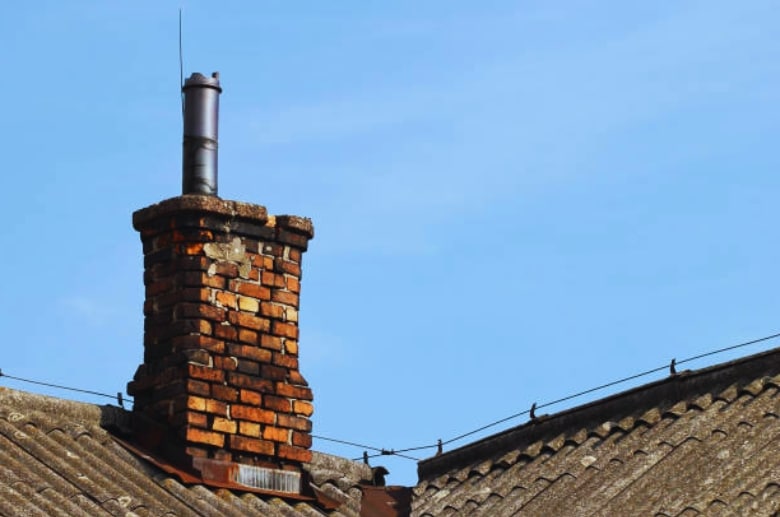 A chimney with bricks falling off.