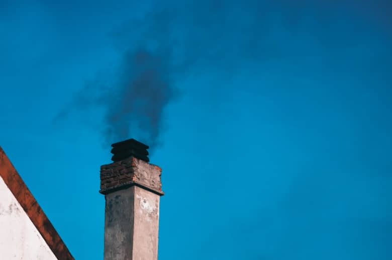 Chimney with a release of white smoke. Wood-fired boiler in a