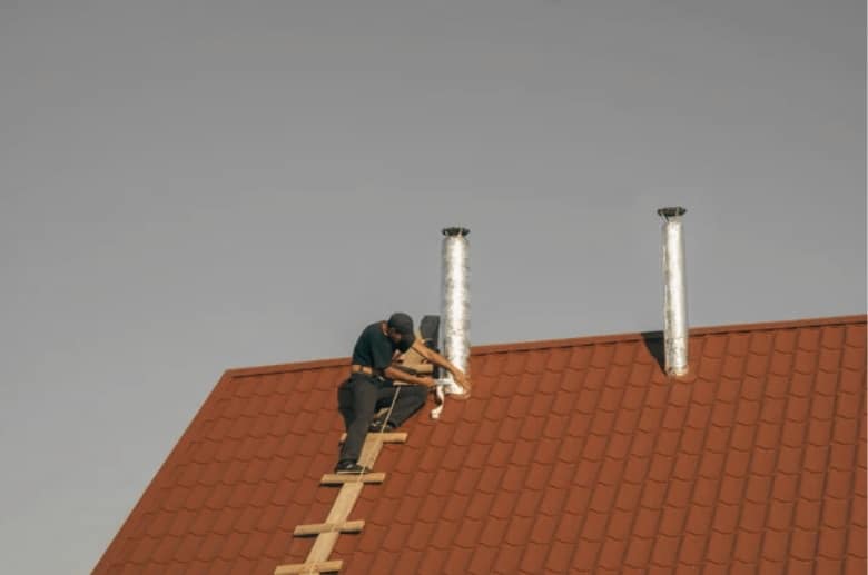 A chimney technician checking a double flue chimney.
