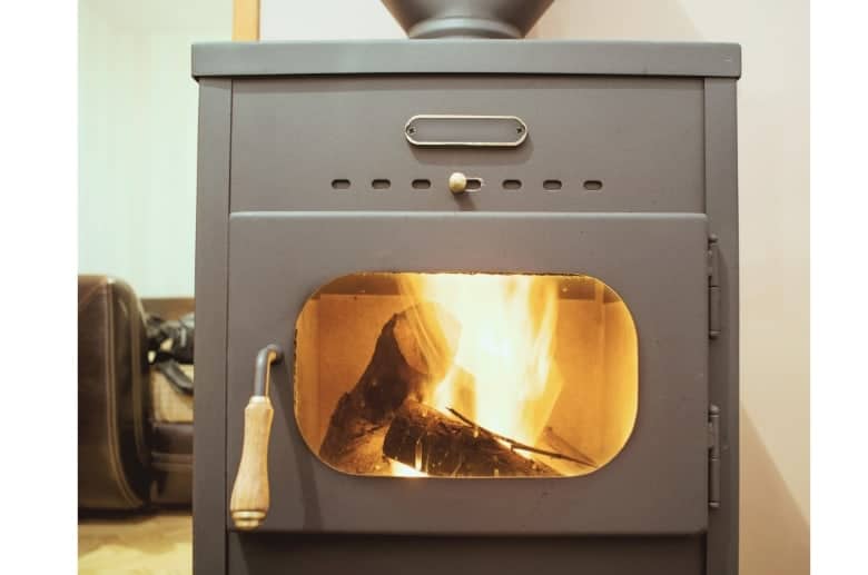 A hybrid wood stove with burning logs.